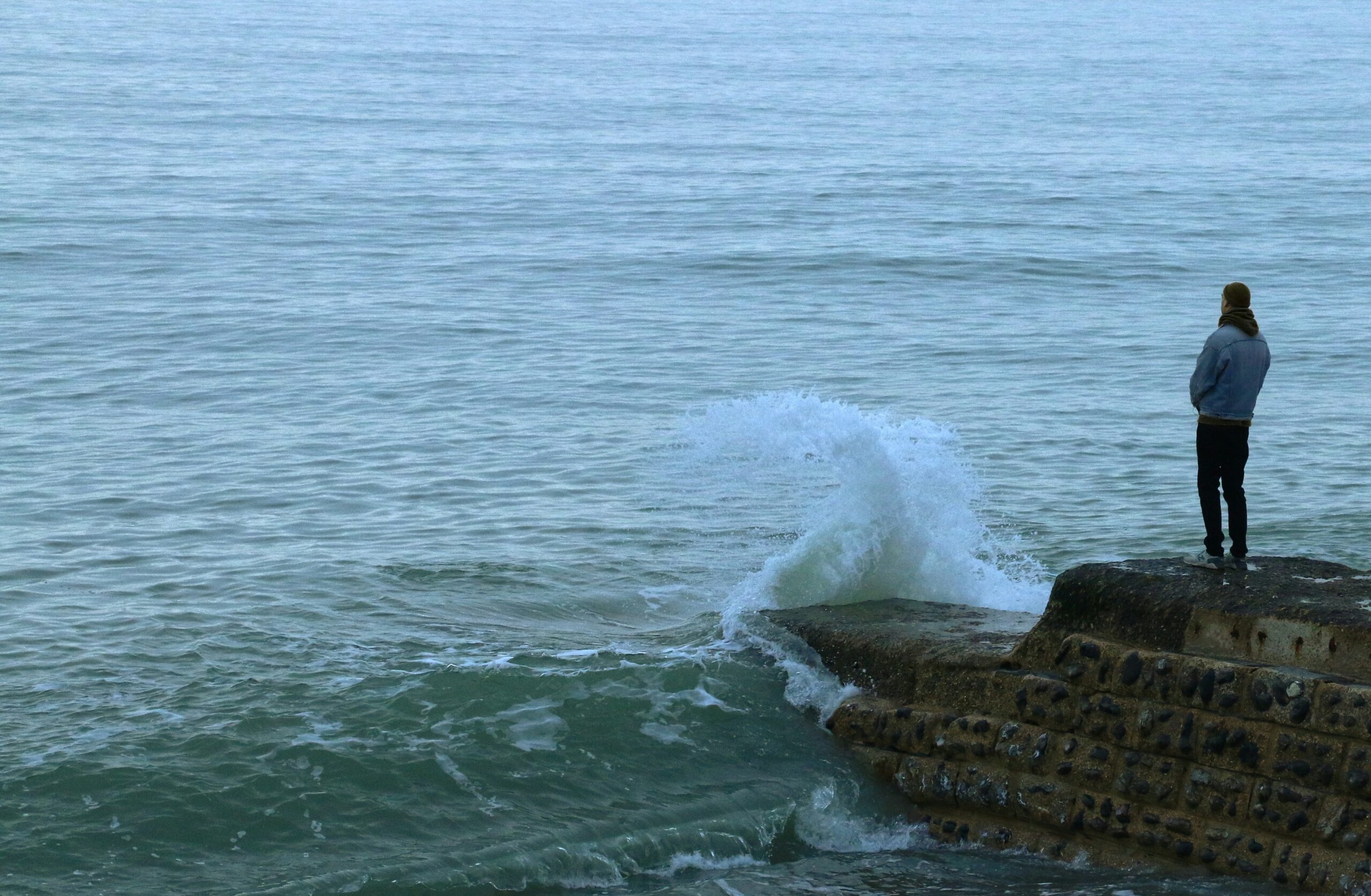 A man stands by the sea.