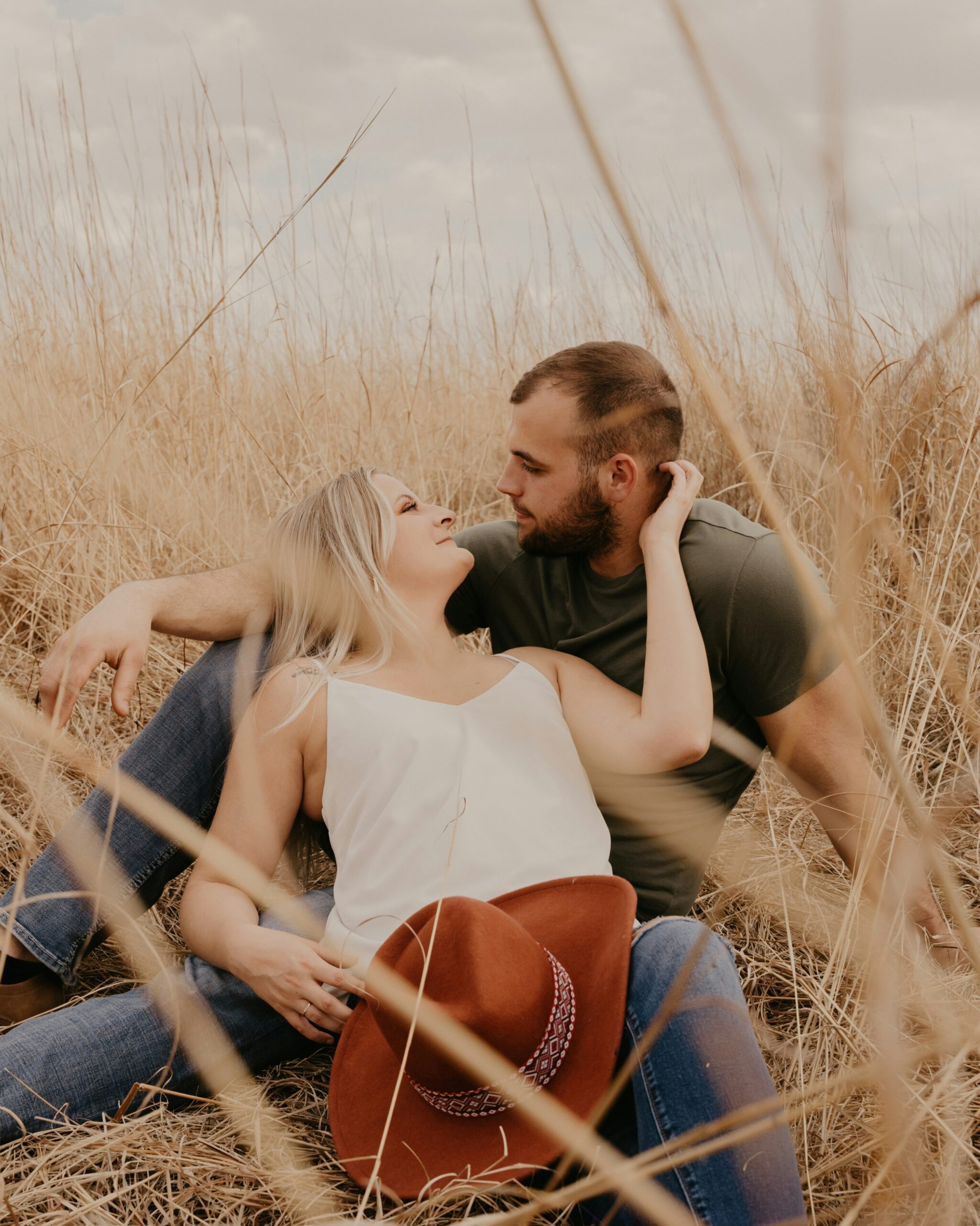A couple sit in a golden field.