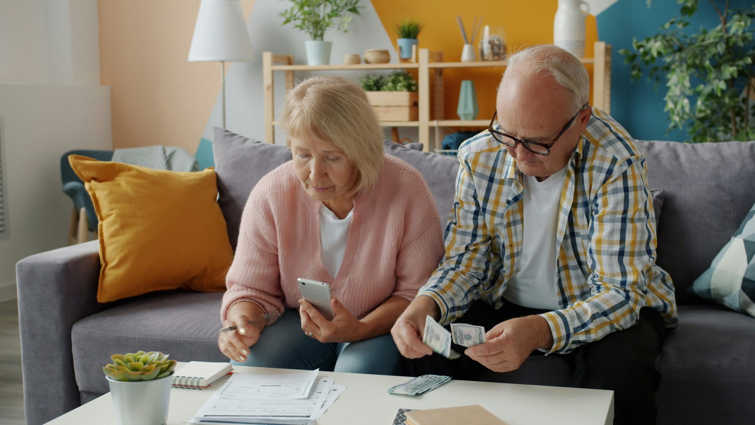 An older retired couple look at money and papers.