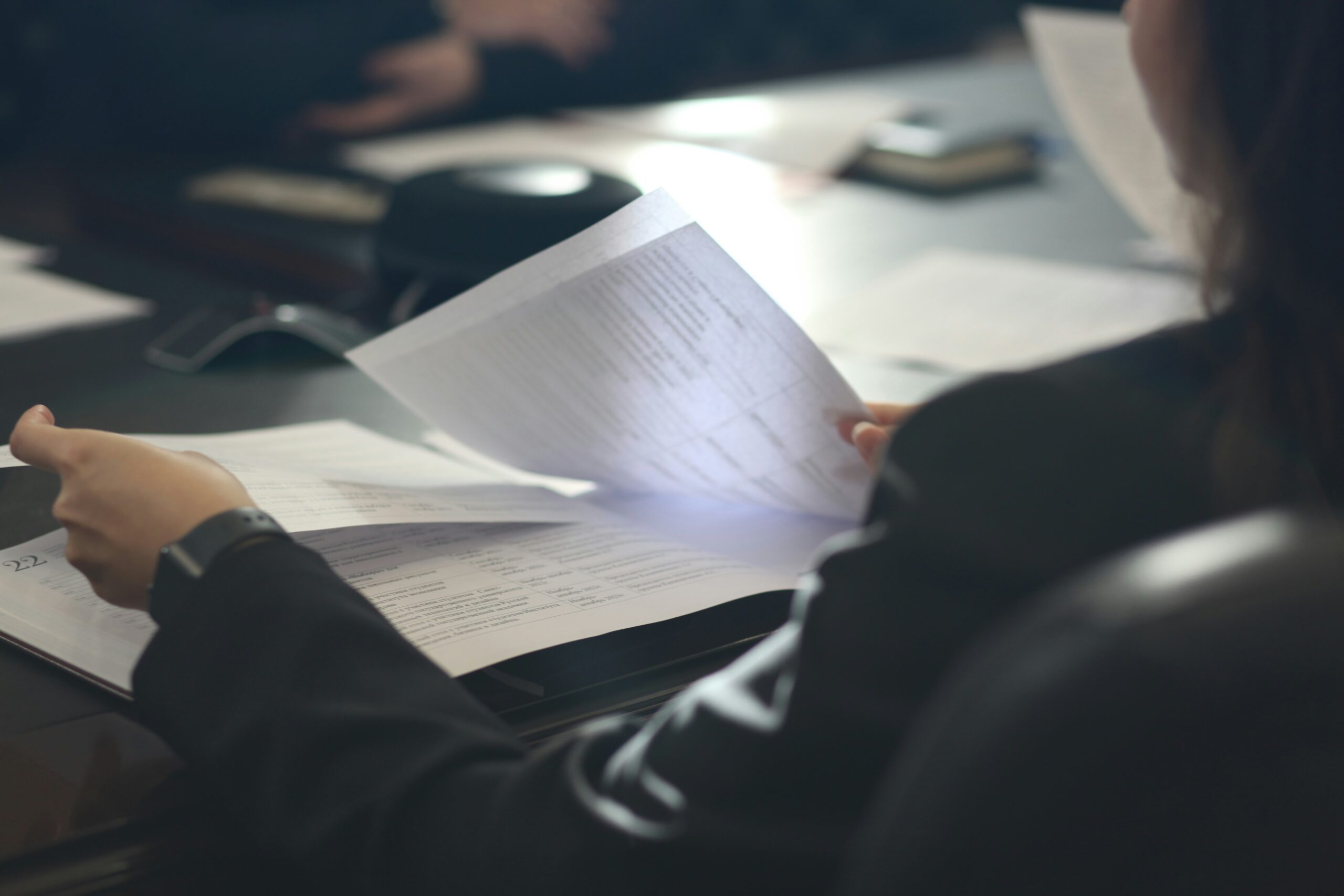 A person looks at papers on a desk.