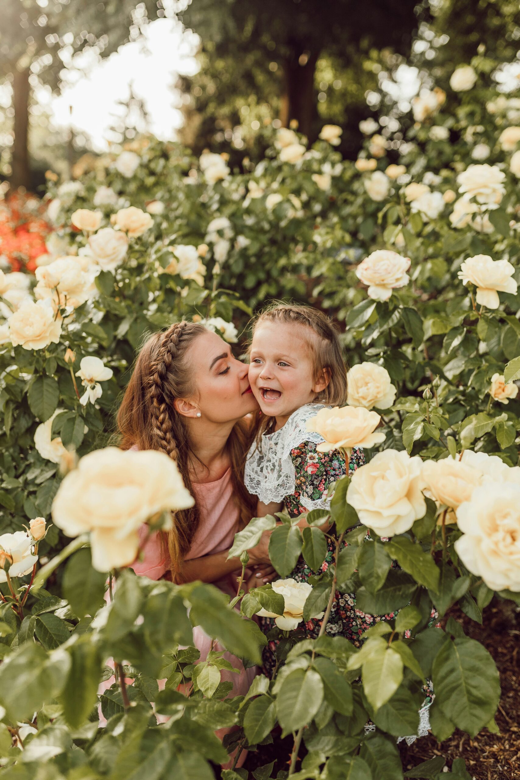 A woman kisses a young girl's cheek.