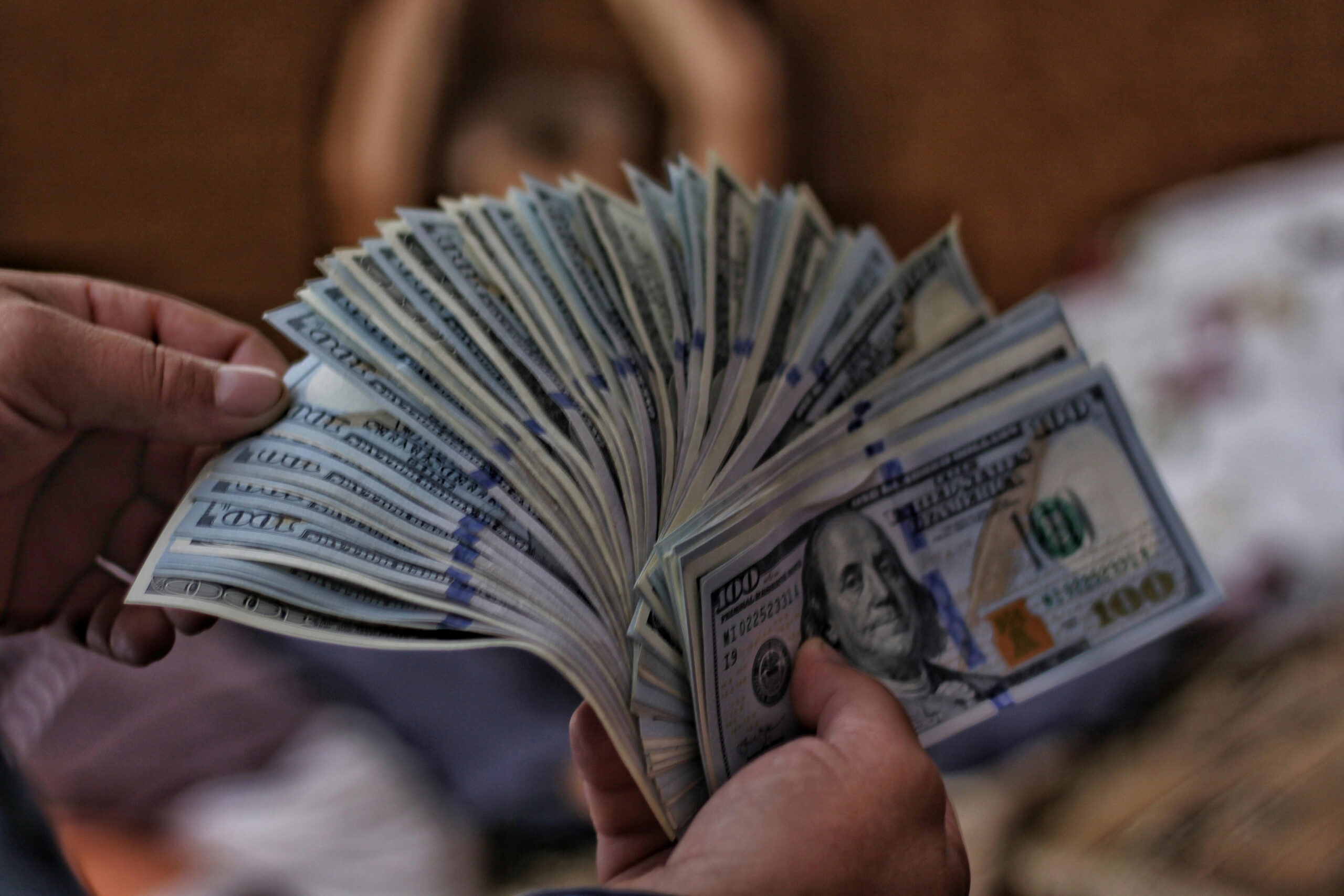 A hand fans paper money out.