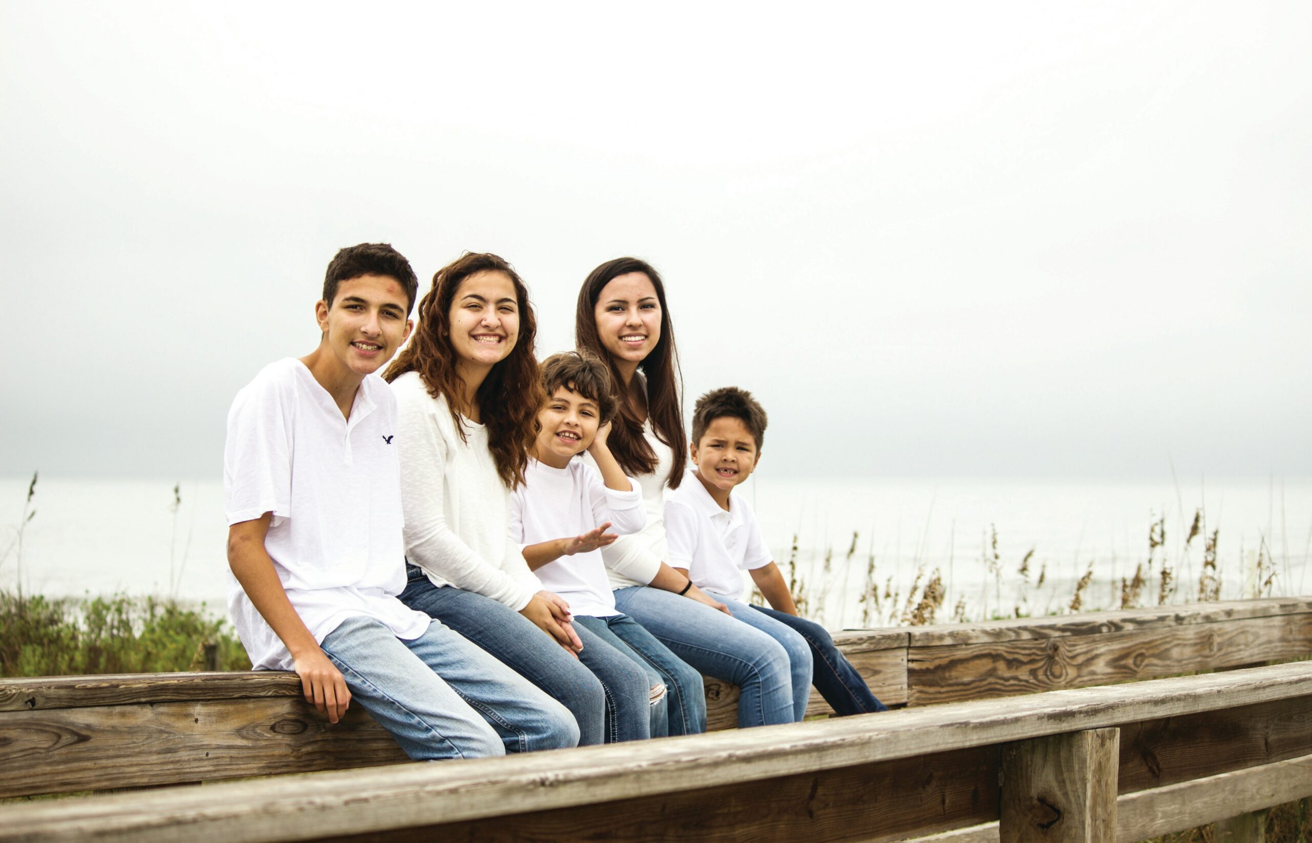 Kids sitting on a railing.